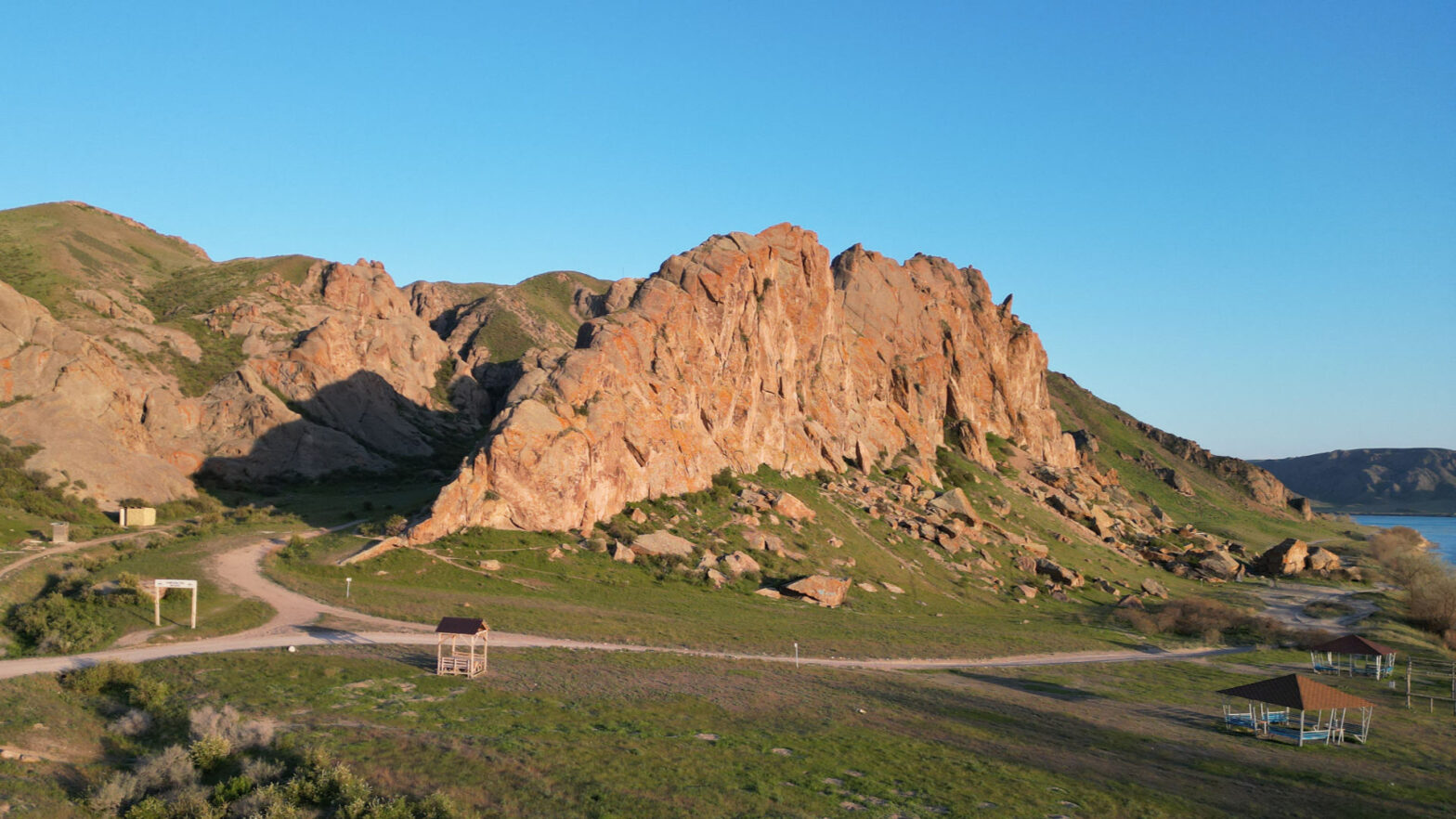 Скалы на закате, кругом свежая трава